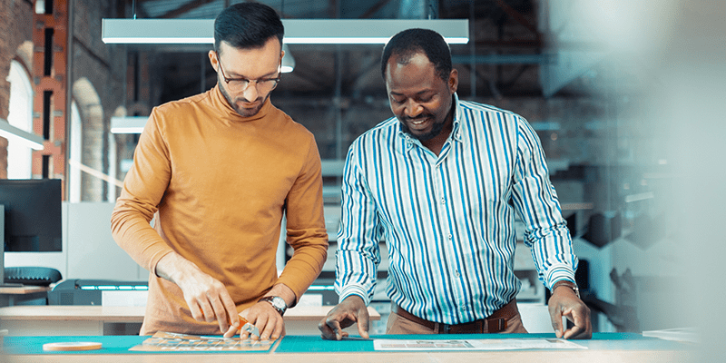 Two Printshop Workers Cutting Printed Material