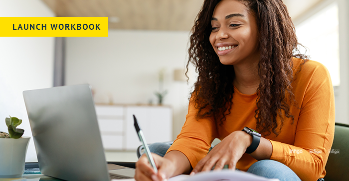 Woman working through workbook with laptop