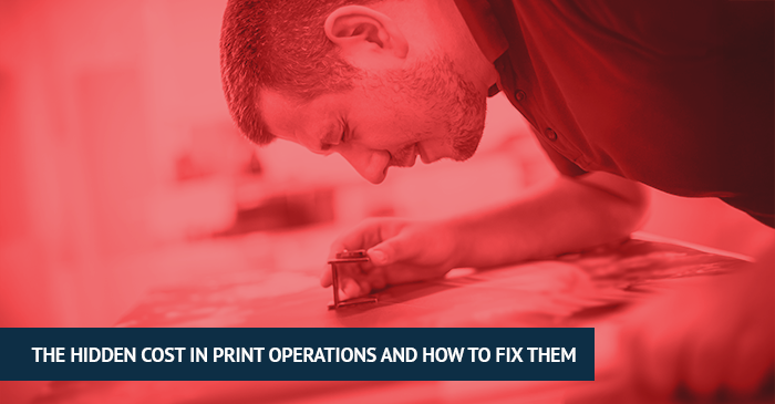 Man carefully inspecting printed material with a magnifying loupe